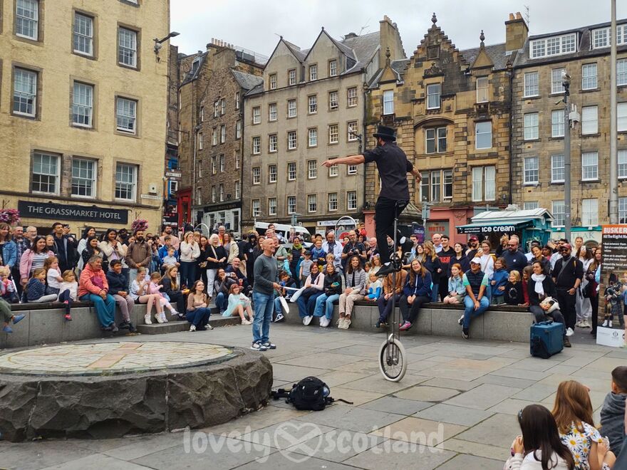 Street performer on a unicycle in Grassmarket during the Edinburgh Fringe