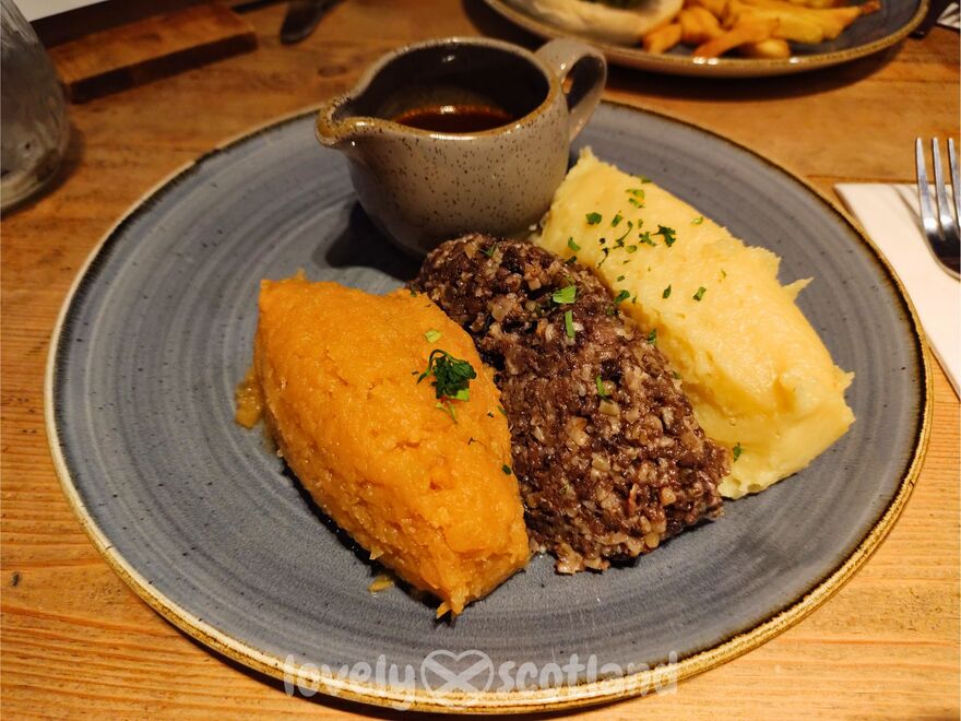 Assiette traditionnelle de haggis avec puree de navet, puree de pomme de terre et sauce au whisky
