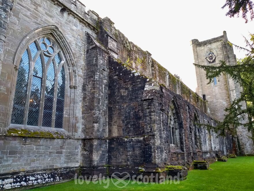Exterior de la catedral de Dunkeld con muros de piedra gran ventanal y torre