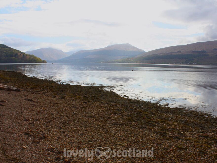 Loch Fyne al oeste de Loch Lomond con orilla pedregosa y montañas al fondo