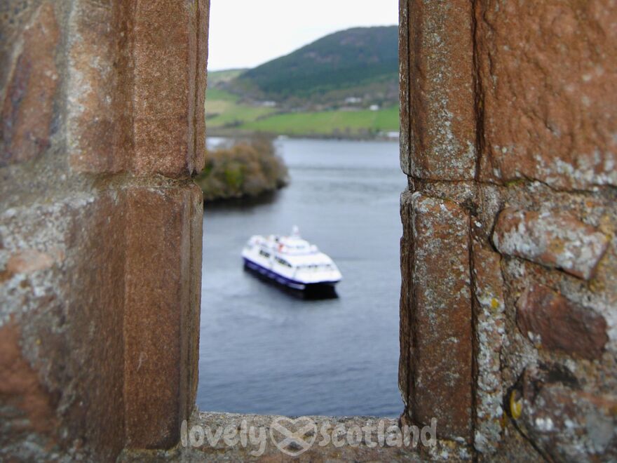 Loch Ness cruise boat seen through a window at Urquhart Castle