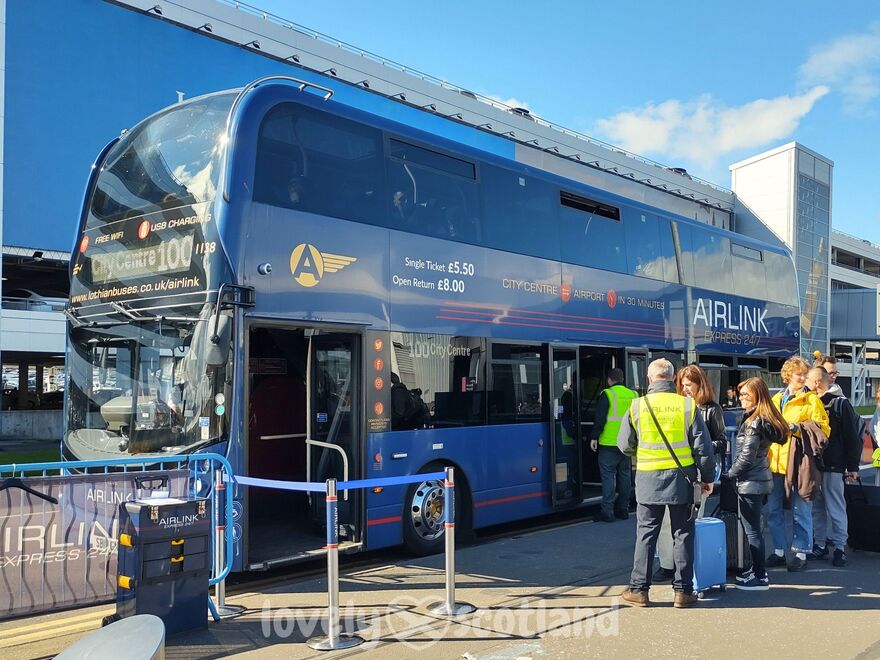 Airlink 100 bus at Edinburgh Airport with travelers boarding for the city center