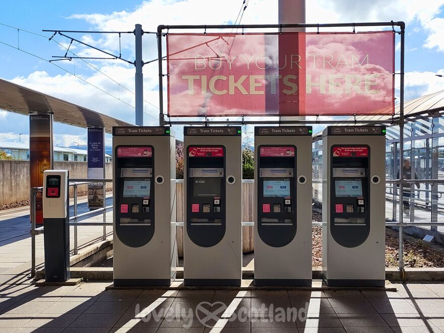 Edinburgh Airport tram ticket machines beside the stop with validator and overhead sign