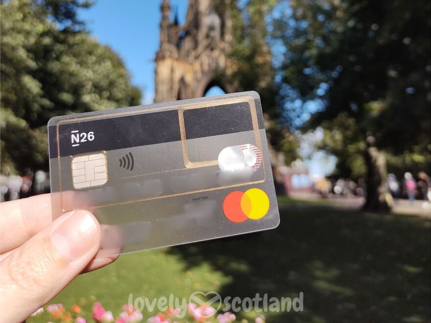 Carte N26 au premier plan avec le Scott Monument flou à Édimbourg