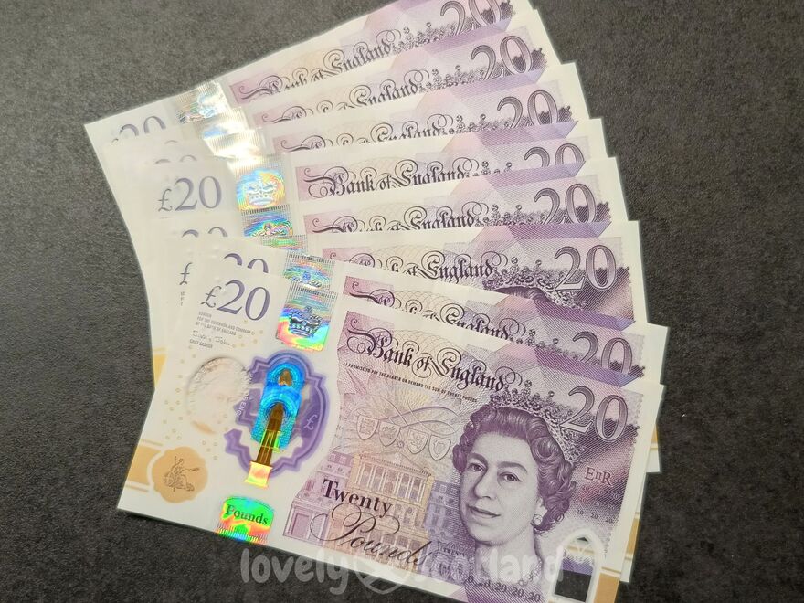 Plusieurs billets en livres sterling étalés avec la reine Elizabeth II sur les billets