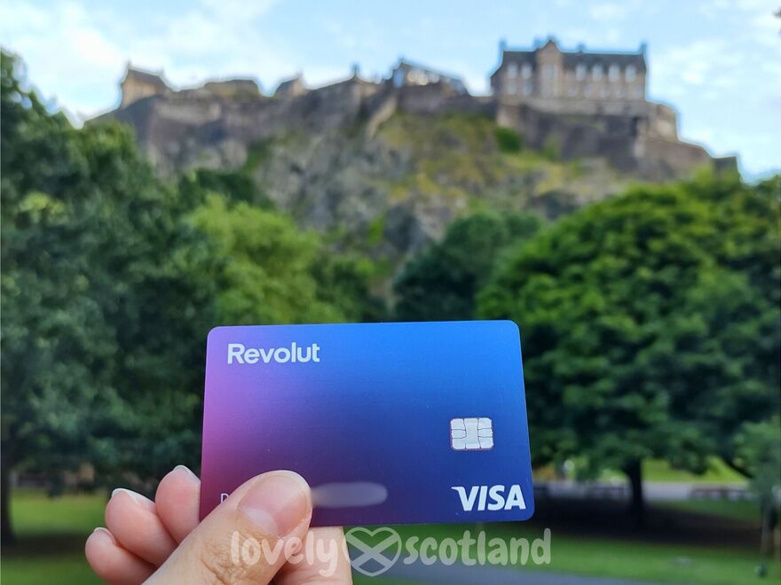 Carte Revolut au premier plan avec le château d’Édimbourg flou au fond