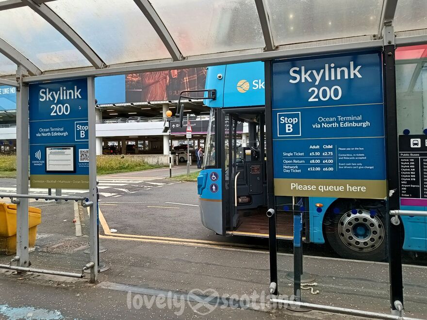 Skylink 200 stop at Edinburgh Airport with bus waiting beside fare and timetable panels