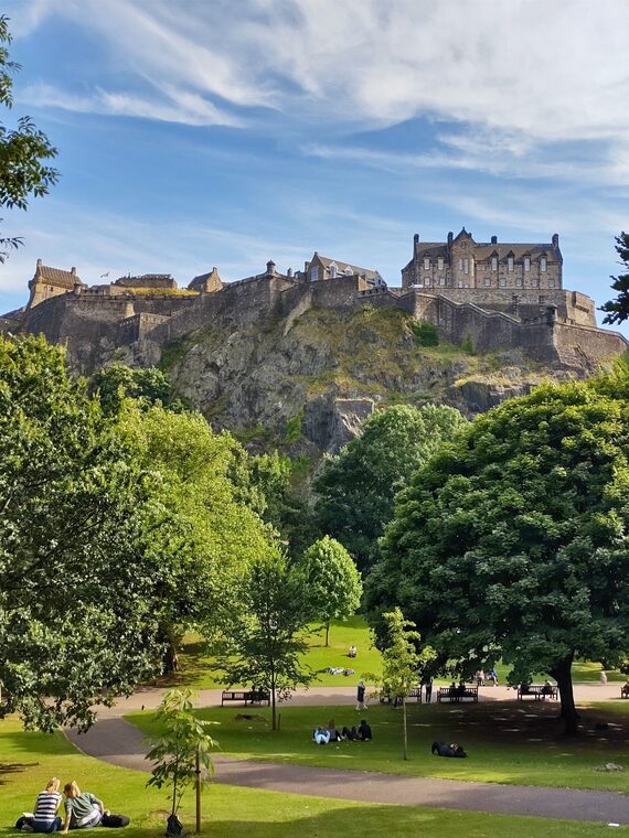 Edinburgh Castle above green lawns in Princes Street Gardens